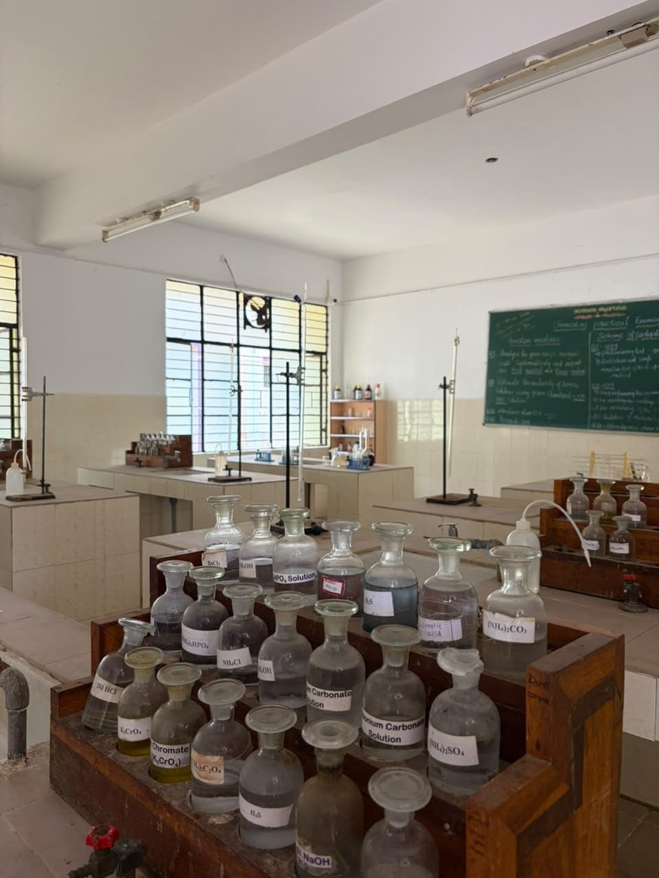 The science laboratory at Mandaara Public School, with labelled reagent bottles and burette stands on the work benches.